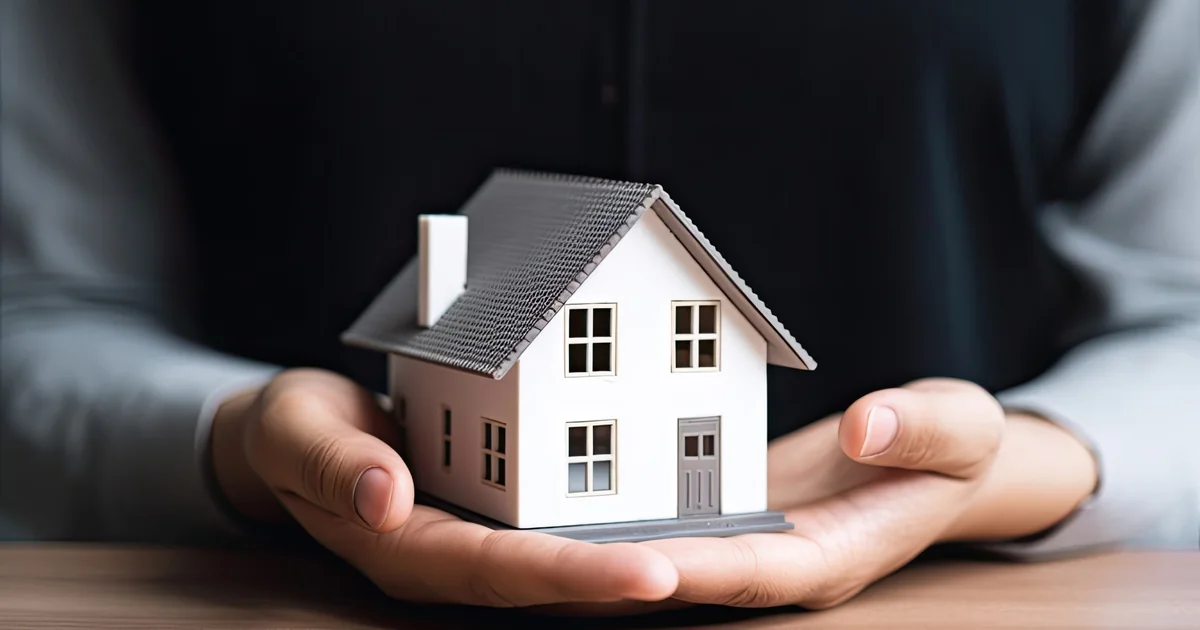 Mani che sostengono il modellino di una casa, simbolo della vendita immobiliare